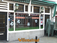 716540 Fotopaneeltje, met een afbeelding van voetbalversieringen op de ruiten van Café Zanzibar, Willemstraat 51 te ...